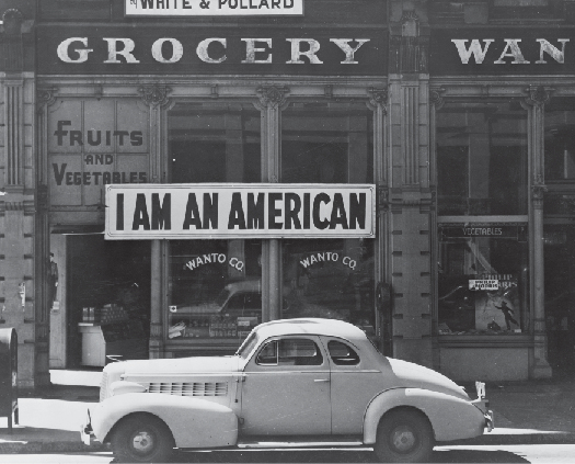 A photo of sign in a store front that says “I am an American.”