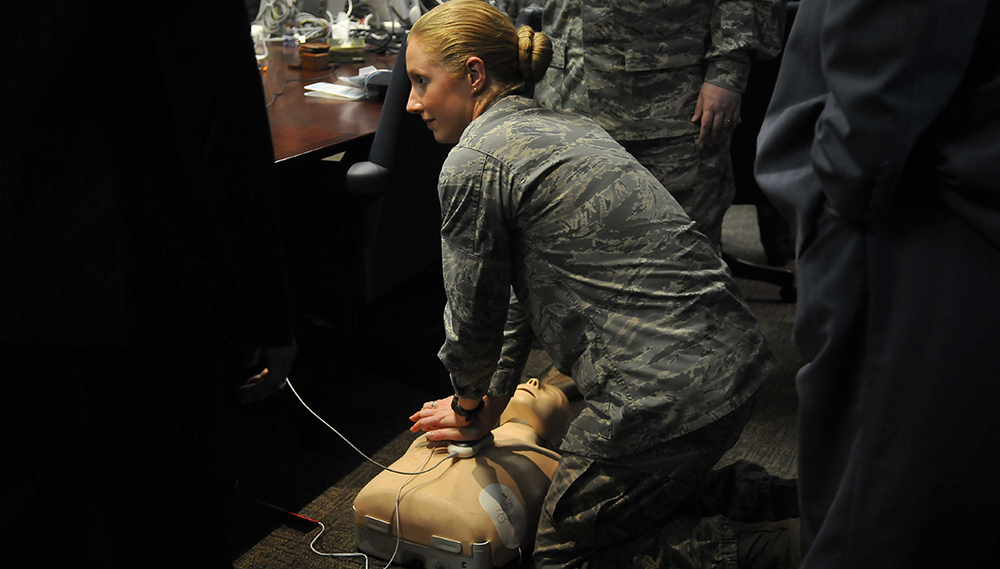 Air Force officials practice using an automated external defibrillator (AED). Electric potential energy is stored in the defibrillator unit and sent to resuscitate the patient.