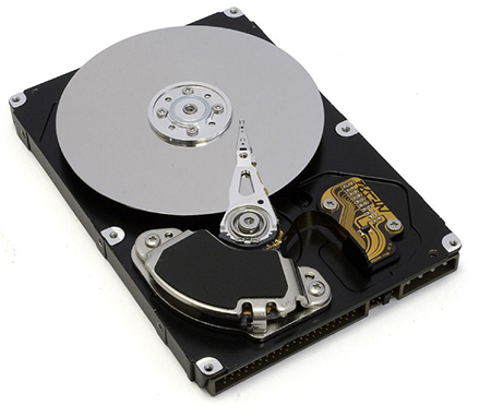 Photo shows the inside of a hard disk drive. The silver disk contains the information, whereas the thin stylus on top of the disk reads and writes information to the disk.