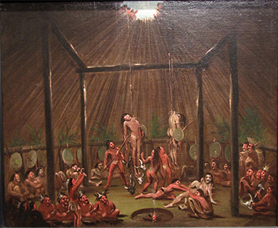 A painting shows several young Native American men suspended by wooden splints, which are stuck through different parts of their bodies. Others participate in the ritual or look on from below.