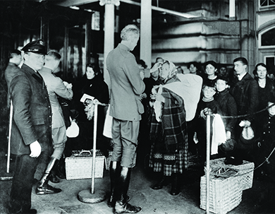 A photograph shows inspectors examining newly arrived immigrants at Ellis Island.