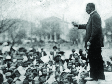 A photograph shows Booker T. Washington speaking and gesturing before a large crowd.
