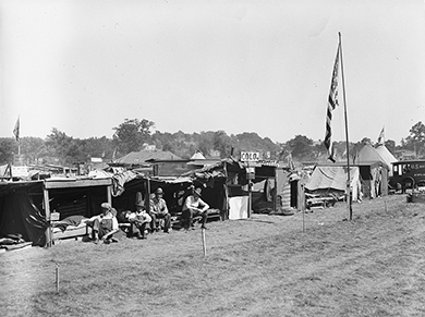 A photograph shows the burning of veterans’ camps at Anacostia Flats.
