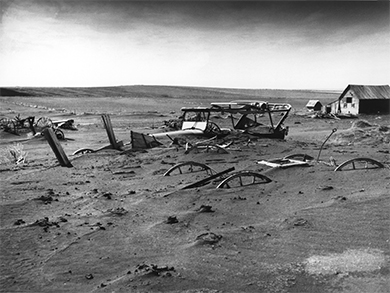 A photograph shows an abandoned farmhouse and farm equipment that were largely buried under dust.