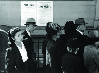 A photograph shows Japanese Americans standing in line in front of a poster detailing internment orders in California.