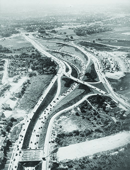 An aerial photograph shows a network of newly constructed highways.