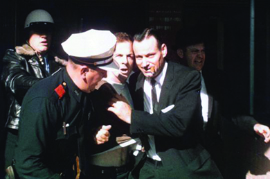 A photograph shows several men arresting Lee Harvey Oswald.