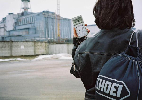 A person holding a hand held radiation detector near the Chernobyl reactor.