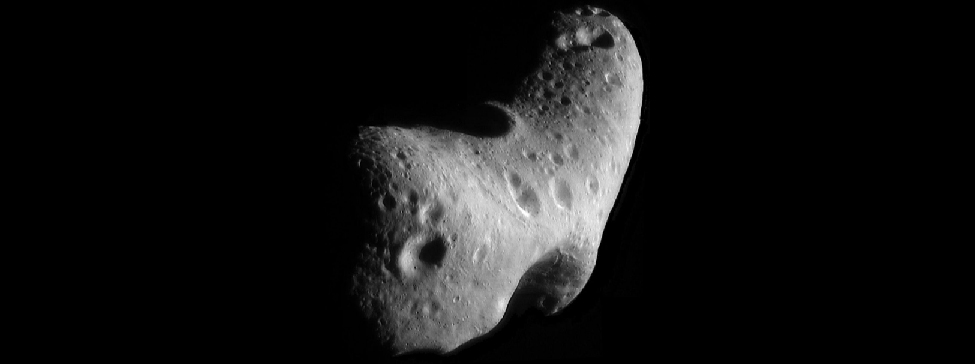 Looking Down on the North Pole of Eros. In this image looking down the length of this somewhat boomerang-shaped asteroid, many craters and surface features can be seen.
