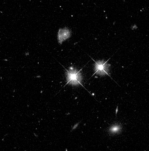 HST Image of a Quasar. The bright, star-like image at the center of this photograph is really a quasar 9 billion light years distant.