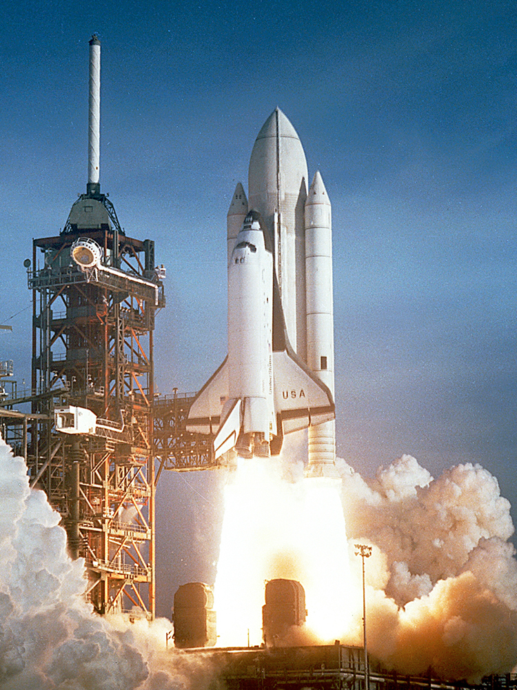 The space shuttle is launched. It consists of the shuttle orbiter, two solid rocket boosters, and an expendable external tank. It takes off leaving much smoke and fire.