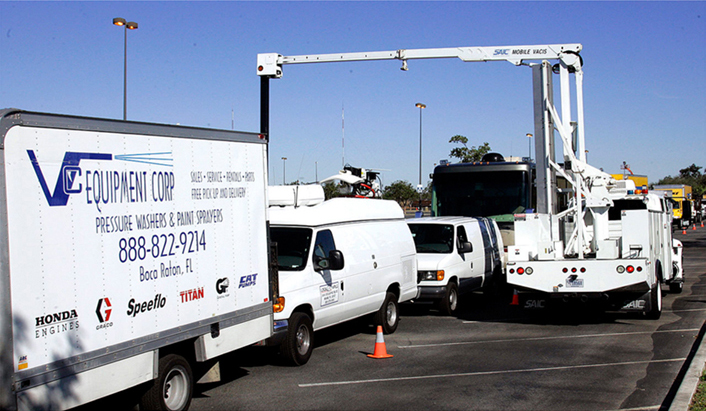 Vehicles being inspected by another vehicle with a boom-type x-ray scanner attached to it.